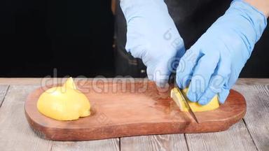厨师在手套上切柠檬在木切割板上。 餐厅的食物咕咕叫。 慢动作。 高清高清